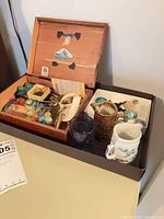 Full lot view: cedar box, two pitchers, blue goblet, glass horses, stones