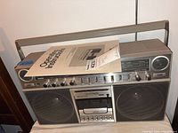 Front view of Panasonic RX-5250 boombox with manual resting on top