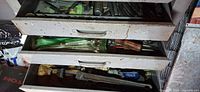Three open drawers with mixed hand tools visible