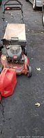 Toro mower front view with bagger frame and one gas can