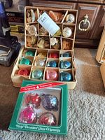 Three boxes of vintage glass Christmas ornaments displayed on carpet