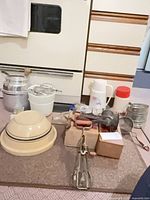 Lot overview showing bowls, utensils, thermoses