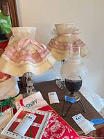 Two glass block lamps with frilled shades beside hurricane-style lamp