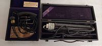 Both open wooden cases showing two separate vintage medical devices with cords and components