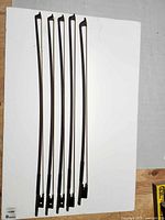 Five Glasser violin bows laid out shaft view
