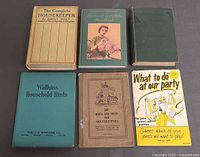 All six vintage household books arranged on surface