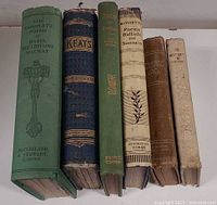 Spine view of all six poetry hardcovers showing titles and wear