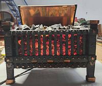 Front view of electric fireplace heater showing cast metal grate and glowing coal effect