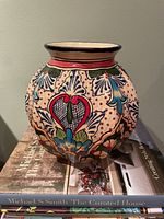 Front view of multicolour Alba Mexico vase on books