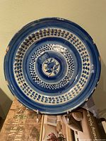 Front view of blue and white Maiolica plate showing design and edge chips