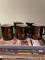 Group of five black zodiac mugs