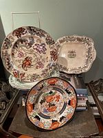 Group shot showing all five plates including Verona plate, floral scroll plate, square handled plate, green reticulated plate, blue-bordered plate