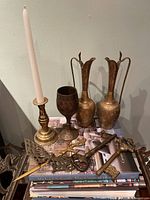 Group of brassware on books: two ewers, goblet, candlestick, letter opener, three keys