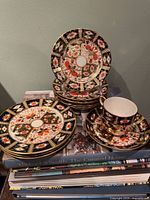 Stack of bread plates, stack of saucers with teacup on top, showing pattern and quantity
