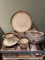 Group shot of all items: plate, two cups, saucer, covered sucrier