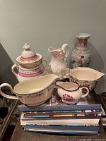 Group of six pottery pieces on books