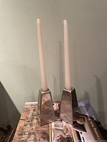 Full view of both aluminum candlesticks with tapers inserted