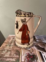 Front view of Royal Doulton Isaac Walton Ware pitcher showing angler graphic and inscription