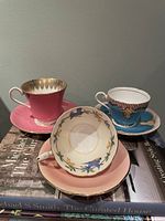 Three Aynsley tea cups and saucers showing patterns and colours