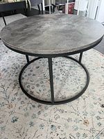 Grey faux concrete-top round table on black metal base
