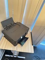 Front angled view showing printer on table with scanner lid open