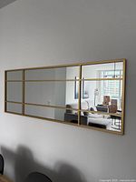 Front view of gold windowpane wall mirror mounted on wall