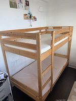 Full view of bunk bed showing frame, mattresses, broken guard rail
