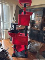 Front view of red and black cat tree showing three perches, condos, hammock, platforms
