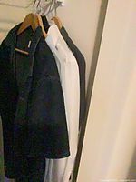 Four shirts hanging: black, white, black variants