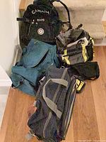 Four assorted travel bags on floor