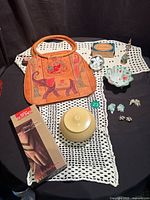 Group shot of purse, gloves, French Ivory box, soap, perfume bottle, dishes, linens