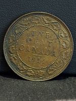 Reverse of 1914 Canadian one-cent coin showing date and maple leaf vine border