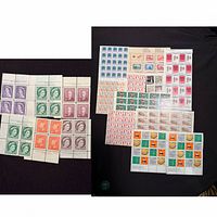 Overview of two groups of mint Canadian stamp blocks and sheets
