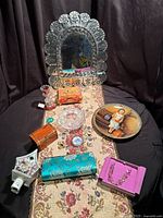 Overview of all items on runner showing mirror, plate, jewellery, boxes, night light, clutch, candle holder