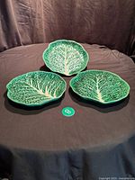 Three green cabbage leaf plates on table
