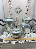 Group shot of coffee pot, teapot and pitcher with ruler for scale