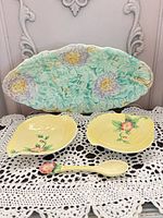 Overall view of oval platter, two leaf dishes and spoon