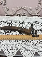 All three railroad spikes with ruler showing length