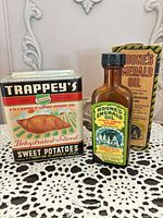 Front view of Trappey’s tin and Moone’s bottle with box