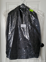Coat in original plastic bag hanging on door