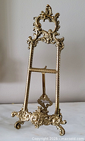 Full front view of ornate brass easel stand
