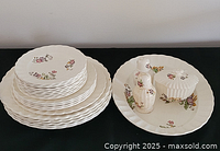 Stacks of dinner and side plates, platter with shakers and covered dish