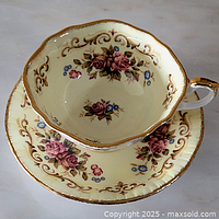 Teacup nested in saucer showing pattern and gold trim