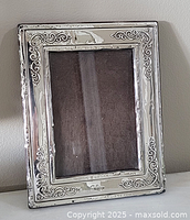 Front view of sterling silver frame showing scroll border and aperture