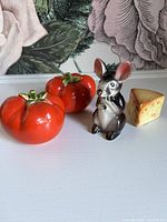 Front view of all four shakers: two tomato, one mouse, one cheese wedge