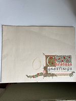 Front cover of 1936 card showing water stain and Christmas Greetings design