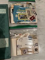 two plastic bags containing assorted stamps and covers placed on top of binder