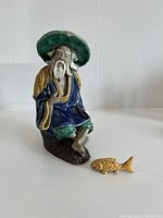 Front view of first Mud Man figurine with gold fish