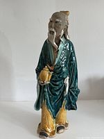 Front view of glazed ceramic elderly man figurine