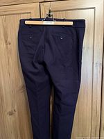 Rear view of royal blue ankle trousers showing button-through pockets